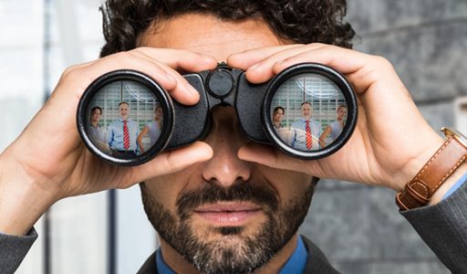 Man using binoculars to look at people
