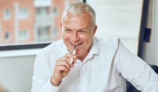 Man sititng at a desk smiling